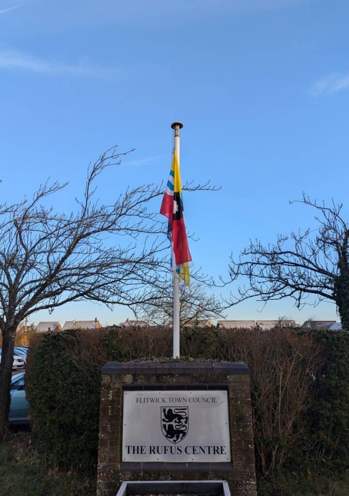 yellow, blue and red Bedfordshire flag flying