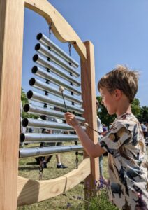 young boy playing outdoor chimes